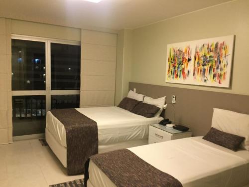 巴西利亚Flat Fusion Setor Hoteleiro Norte com serviço diário de limpeza的酒店客房设有两张床和窗户。