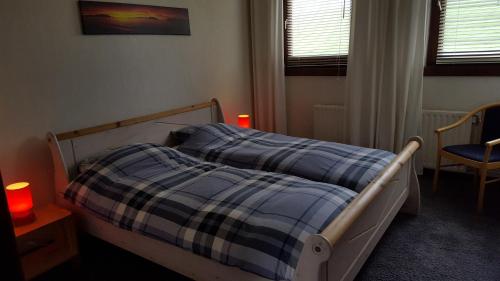 诺尔贝克Vakantiewoning Kleijnen的一间卧室配有一张带蓝色铺面毯子的床