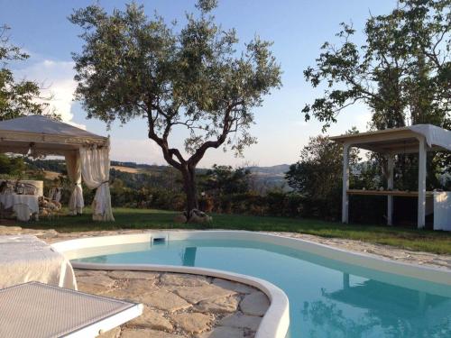 Montefiore ConcaVilla Tamara Country & Spa Suites的一个带凉亭的庭院内的游泳池