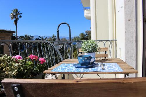 雷焦卡拉布里亚La Casa di Aurora的阳台上的一张木桌和一杯蓝色咖啡