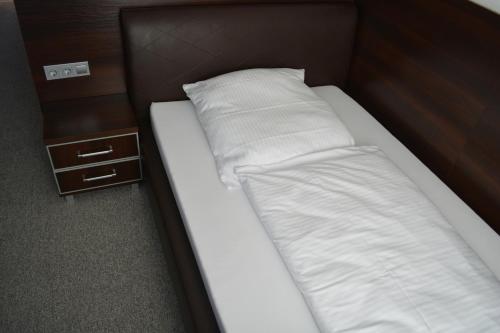汉诺威B&D酒店的一张带白色床单和枕头的床,旁边是2个床头柜