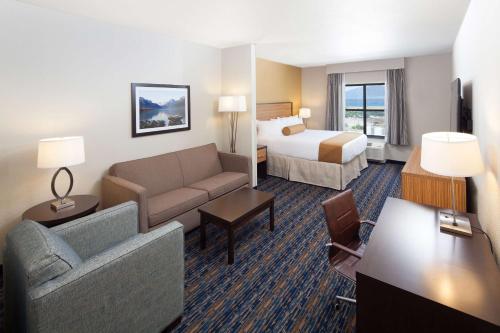 波尔森波尔森红狮水岭酒店和套房的酒店客房设有一张沙发和一张床