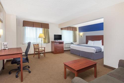 迪比克杜布克贝蒙特旅馆套房酒店的配有一张床和一张书桌的酒店客房