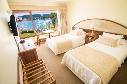 瓦尔迪维亚德尔里奥码头别墅酒店的酒店客房设有两张床和大窗户。