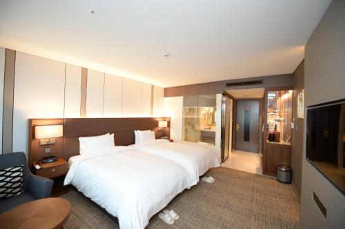 大邱大邱英特博果酒店的卧室配有一张白色大床和电视。