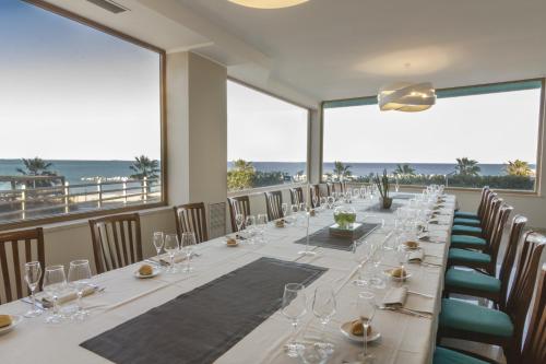 泰尔莫利梅里迪亚诺酒店的长长的用餐室配有带酒杯的长桌