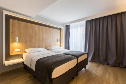 卢布尔雅那M酒店的一间卧室设有一张大床和一个大窗户