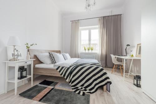 华沙P&O Apartments Andersa INTRACO的白色卧室配有床和桌子