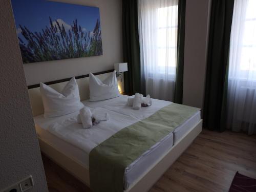 瑙恩Garni Hotel Lavendelhof的卧室配有白色床和毛巾