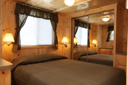 MiltonBlackhawk RV Campground Cabin 1的小木屋内一间卧室,配有两张床