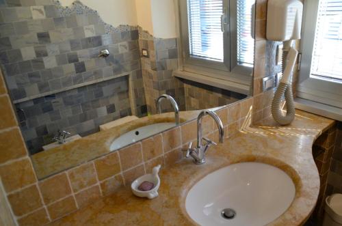 米兰复地之屋旅馆的一间带水槽的浴室和墙上的一部电话