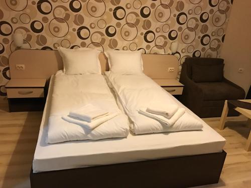 VratsaHotel Body M的一张带白色床单和枕头的床