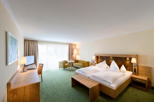 巴特法兴格公园酒店的酒店客房设有一张大床和一张书桌。