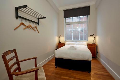 伦敦绿色客房酒店的卧室配有床、椅子和窗户。