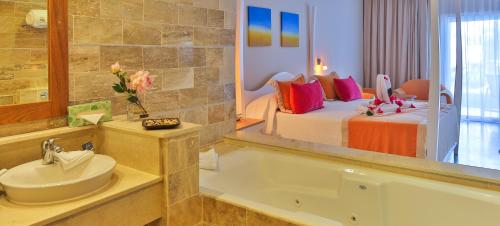 圣斐利-银港Cofresi Palm Beach & Spa Resort - All Inclusive的一间带床、浴缸和水槽的浴室