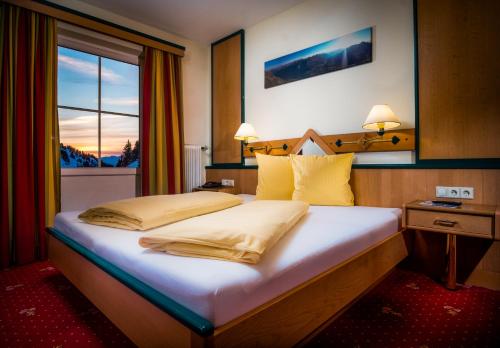 上陶恩温伯格酒店的一间卧室设有一张大床和窗户