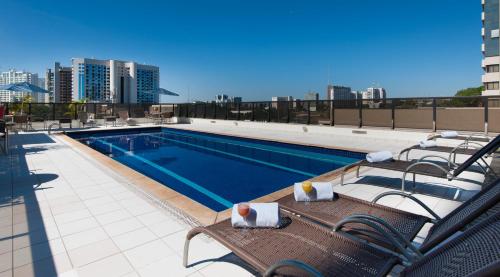 巴西利亚舒适巴西利亚套房酒店的建筑物屋顶上的游泳池