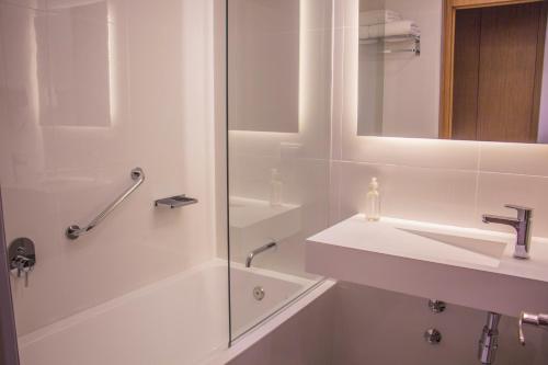 亚松森Esplendor by Wyndham Asuncion的白色的浴室设有水槽和淋浴。