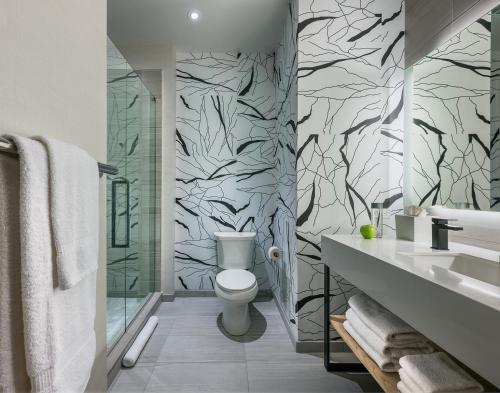 丹伯里丹伯里零度酒店的浴室设有白色卫生间和黑白墙纸。