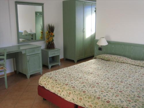 瓦尔迪登特罗雷西亚农家乐的一间卧室配有一张床、一张书桌和一面镜子