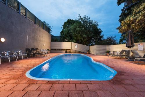 纳鲁马Horizon Holiday Apartments的一个带桌椅的庭院内的游泳池