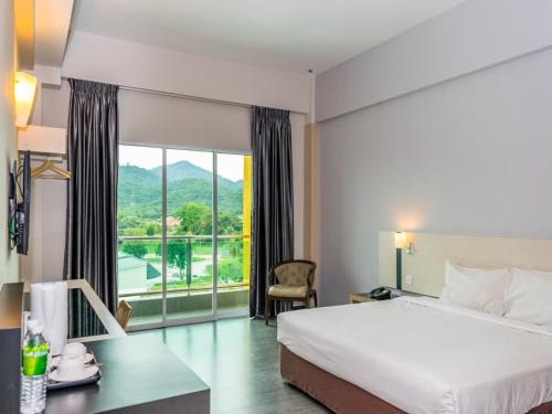 怡保MH Sentral Hotel Sg Siput的酒店客房设有一张床和一个大窗户