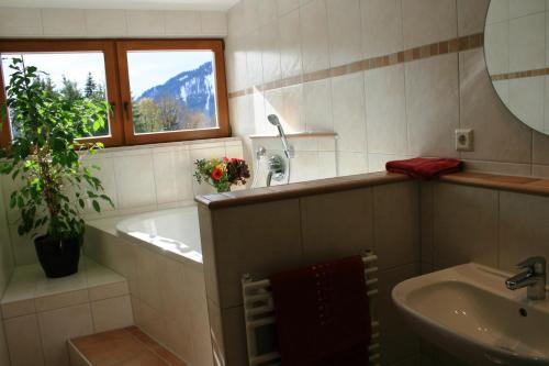 韦尔塔赫埃尔彭霍夫瑞特瓦利酒店的一间带水槽和浴缸的浴室以及窗户。
