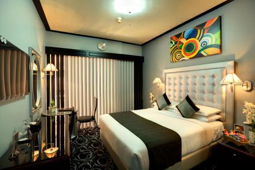 迪拜百老汇酒店的配有一张床和一张书桌的酒店客房