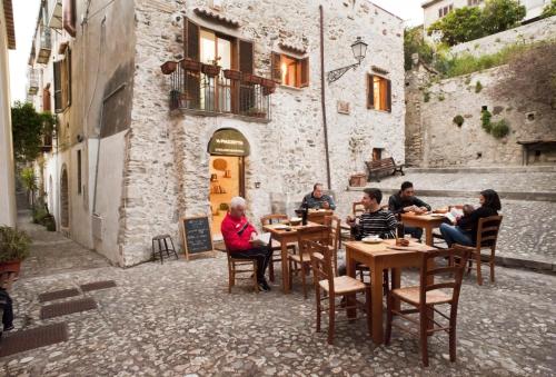 菲乌梅夫雷多布鲁齐奥Residenza d'Epoca Borgodifiume的一群坐在小巷桌子上的人