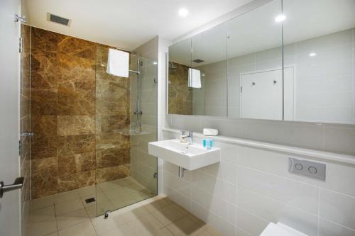悉尼G1908S 泽特兰- 住宅区公寓的浴室配有盥洗盆和带镜子的淋浴
