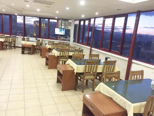 加济安泰普尼尔酒店的餐厅设有桌椅和窗户。