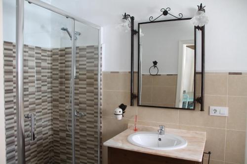 贝纳马奥马La Fuente De El Nacimiento的浴室配有盥洗盆和带镜子的淋浴
