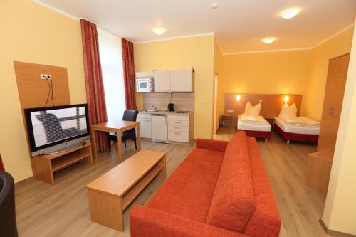 施塔德Appartementhotel in Stade的带沙发、床和电视的客厅