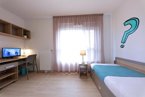 波尔多Apparteo Bordeaux的一间卧室配有一张床、一张书桌和一个窗户。