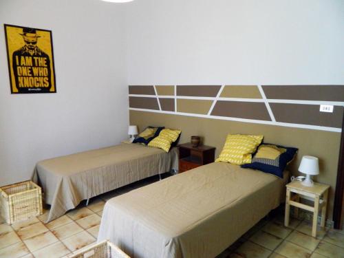 特雷比萨切Casa Relax Mare Trebisacce的卧室配有两张床,墙上有标志