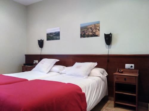 阿尔格达斯Camino de las Bardenas的酒店客房带两张红色和白色的床单