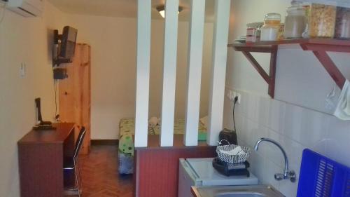 马普托The Quiet Corner Guest House的一个带水槽的厨房和一个带条纹墙的走廊