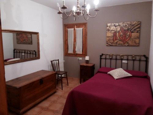 ChiblucoCasa Rural Benede的一间卧室配有一张床、一张桌子和一面镜子