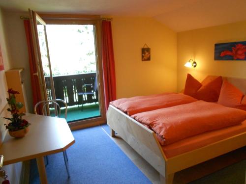 奥布施泰希豪斯特尔纳酒店的一间卧室配有带橙色床单的床和窗户。