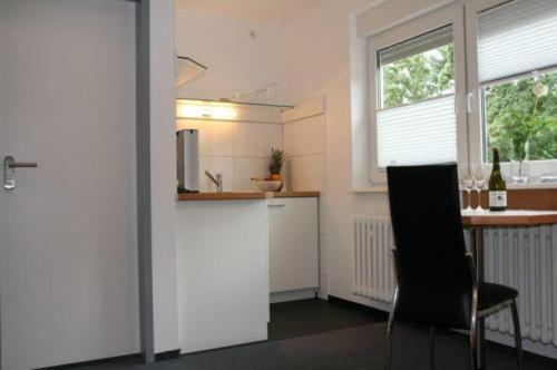 科隆豪斯公寓的厨房配有柜台、桌子和椅子