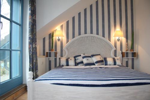 PutgartenFerienwohnung Urte in Putgarten , Kap Arkona Rügen的卧室配有白色床和蓝色及白色枕头
