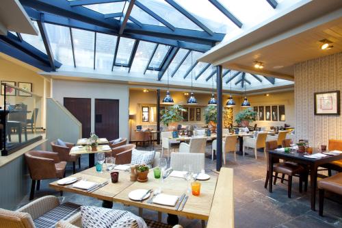 布罗德韦百老汇酒店的餐厅设有木桌、椅子和窗户。