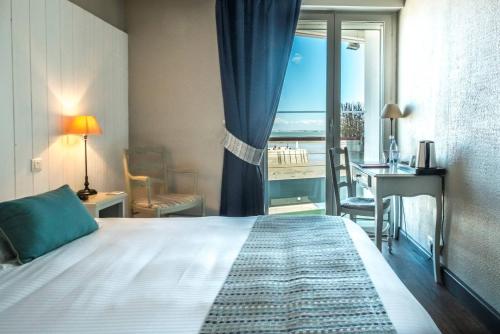 里夫杜海滩Hôtel de La Marée - Face à l'océan - Ile de Ré的一间卧室配有一张床,享有海景