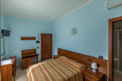 托莱港阿洛吉塔尼亚旅馆的一间卧室配有一张床、梳妆台和书桌