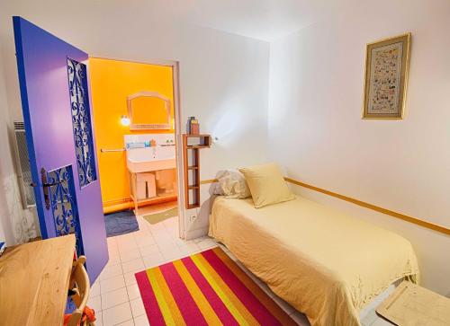 巴黎Paris-Oasis "All Inclusive"的一间卧室配有床,另一间色彩缤纷的客房