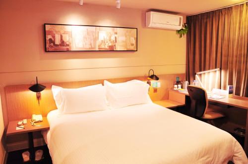苏州锦江之星品尚吴江同里云梨桥酒店的酒店客房设有一张大床和一张书桌。