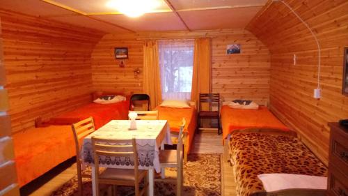AlatskiviKalamehe Farmstay的一间设有三张床的房间,内设一张桌子