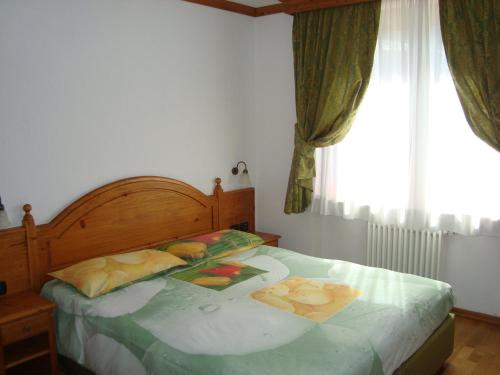 尚波吕克Affittacamere La Falconetta的一间卧室配有一张带木制床头板的床