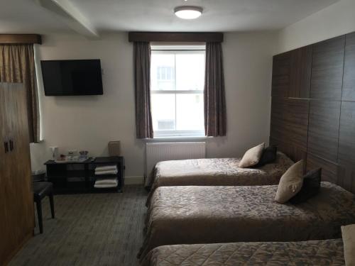 布莱顿霍夫Brighton Beach Inn的酒店客房设有两张床和电视。