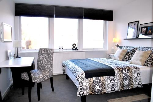 哥本哈根M18酒店的一间卧室配有一张床和一张桌子及椅子
